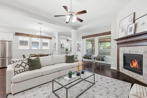a living room with furniture a fireplace and a ceiling fan