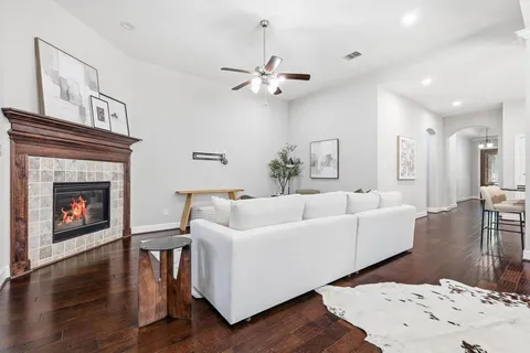 a living room with furniture a fireplace and wooden floor