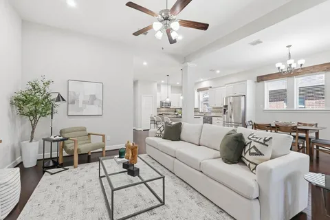 a living room with furniture white walls and a chandelier