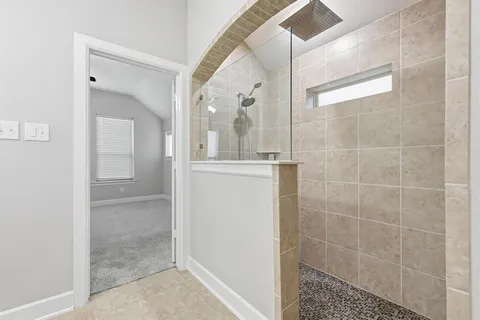 a bathroom with a glass shower door and a window
