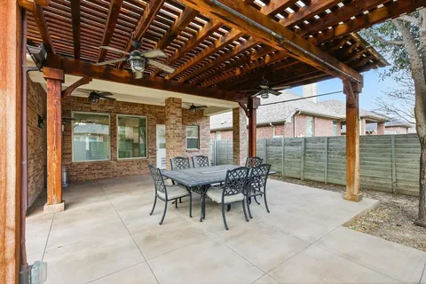 a patio with glass top table and chairs