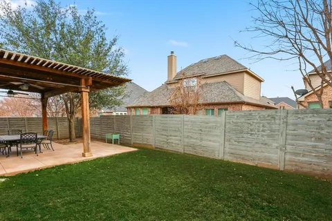 a view of a chair and table in backyard of the house