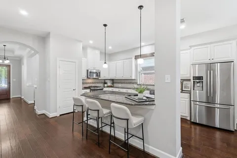 a kitchen with kitchen island white cabinets and stainless steel appliances