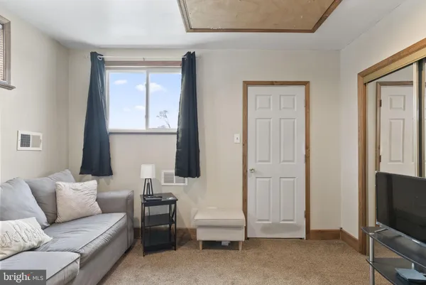 a living room with furniture a flat screen tv and a window