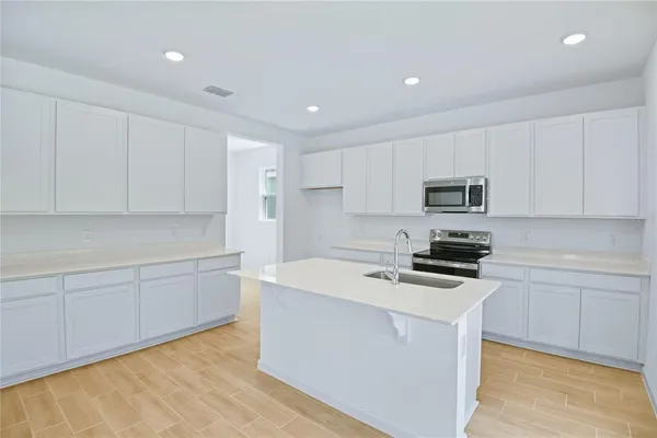 a kitchen with granite countertop white cabinets and white appliances