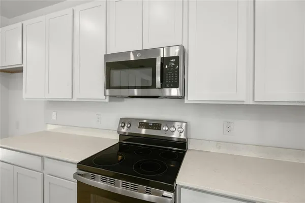 a kitchen with stainless steel appliances a stove a microwave and cabinets