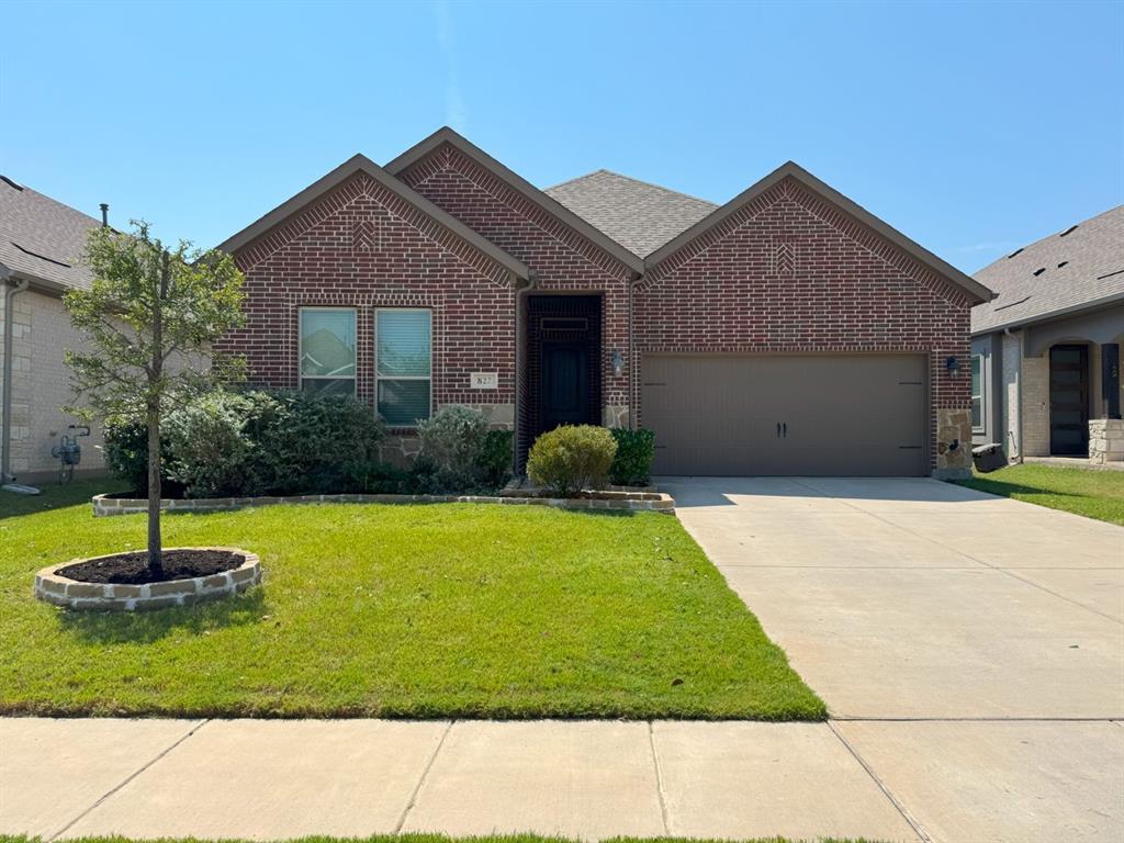 Ranch-style house featuring brick siding, an attached garage, and driveway