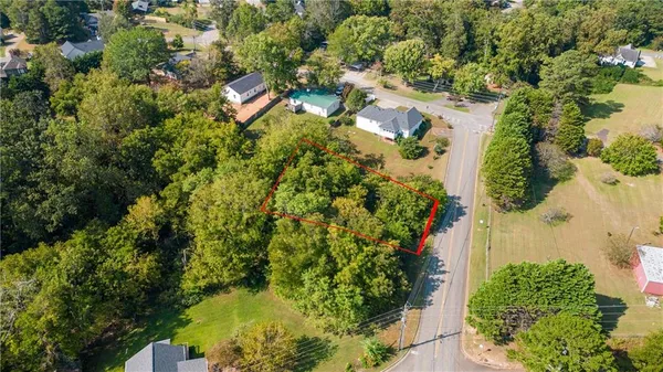 an aerial view of residential house with outdoor space and trees all around