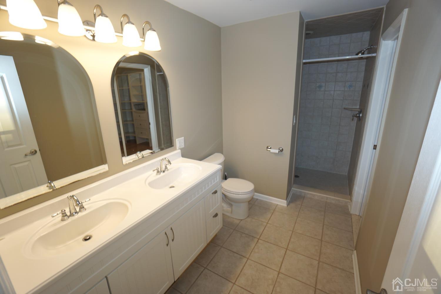 164 Normandy Road Colonia, NJ 07067 - Photo 22 of 47 a spacious bathroom with a double vanity sink and mirror with toilet