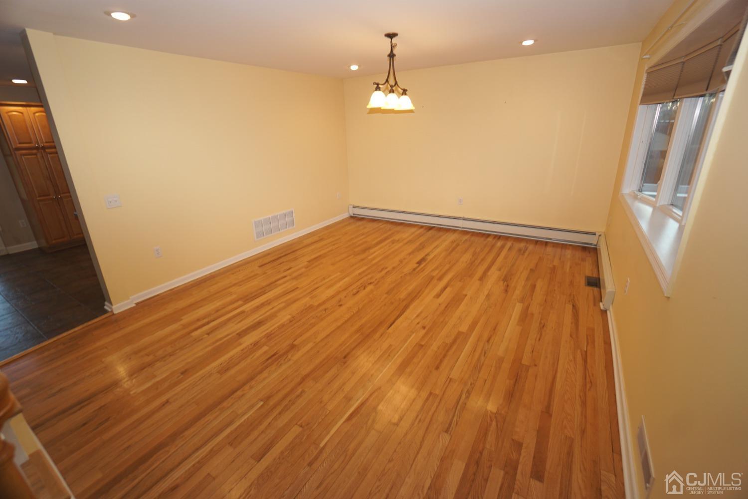 164 Normandy Road Colonia, NJ 07067 - Photo 8 of 47 a view of an empty room with wooden floor and a window