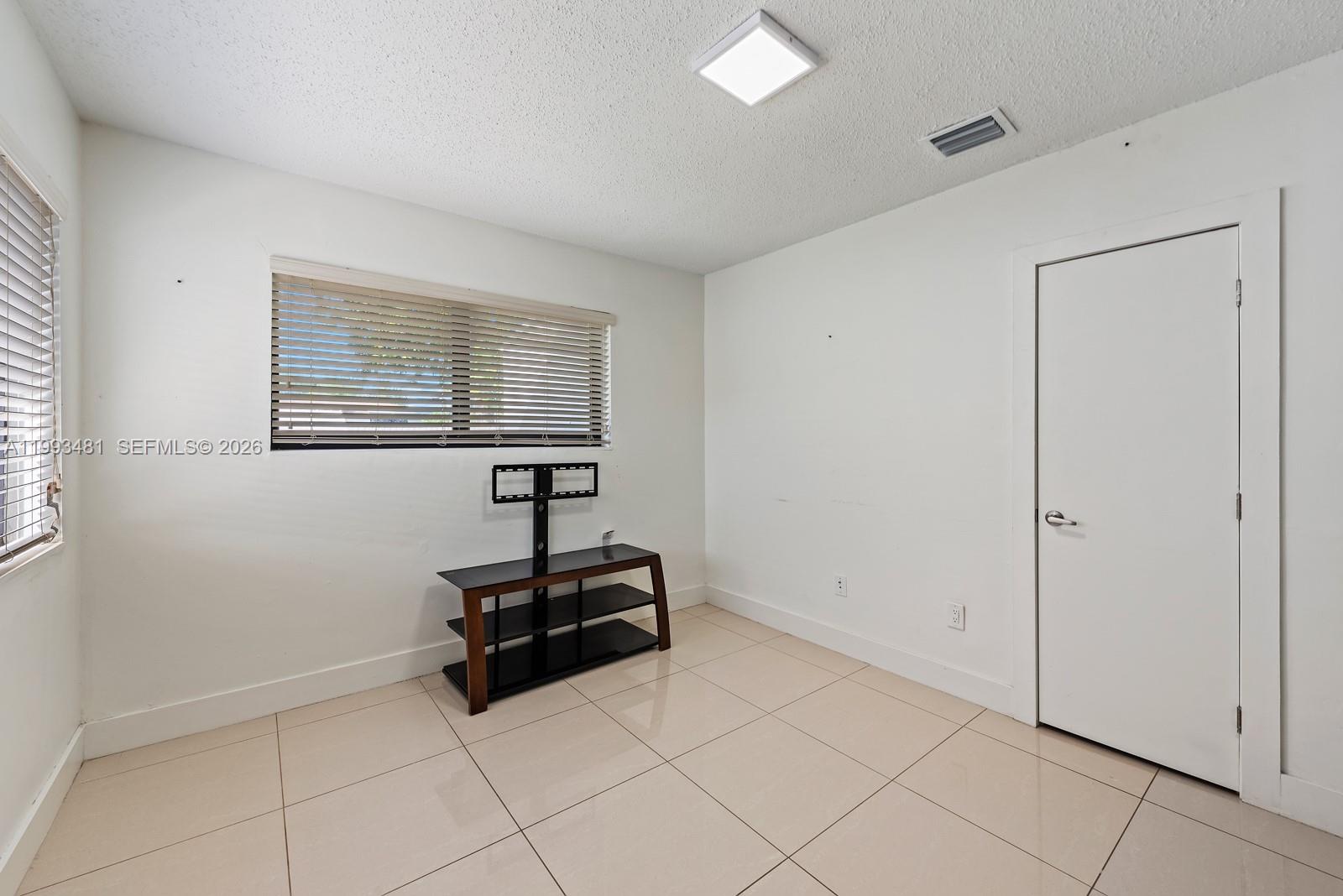 1911 Northwest 30th Street, Unit 4 Miami, FL 33142 - Photo 5 of 15 a room with a dresser and a window