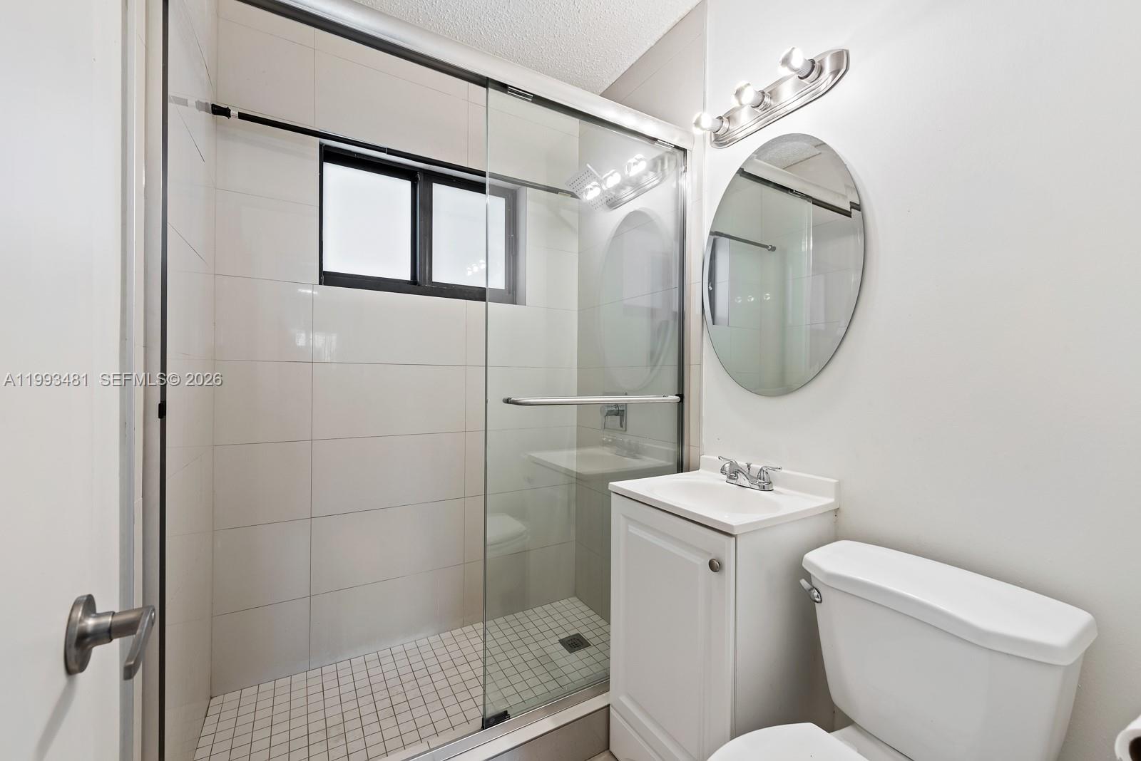 1911 Northwest 30th Street, Unit 4 Miami, FL 33142 - Photo 9 of 15 a bathroom with a toilet a sink and mirror