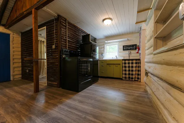 a view of an empty room with wooden floor and windows