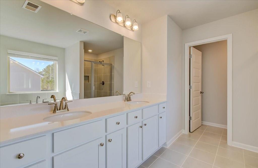 601 Button Grove Stockbridge, GA 30281 - Photo 33 of 37 a bathroom with a double vanity sink and a mirror