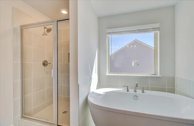 a bathroom with a bathtub a shower and a sink