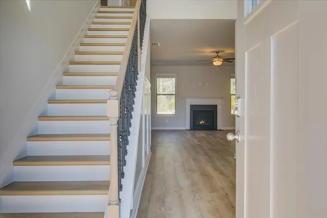 a view of a hallway with wooden floor and fireplace