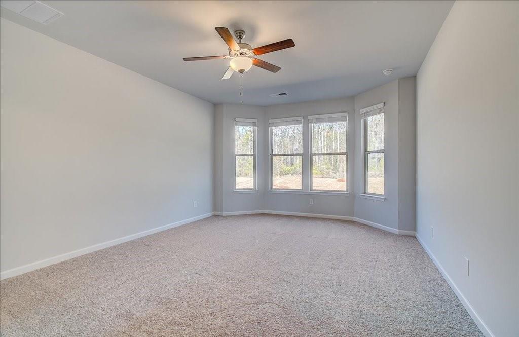 601 Button Grove Stockbridge, GA 30281 - Photo 6 of 37 an empty room with ceiling fan and windows