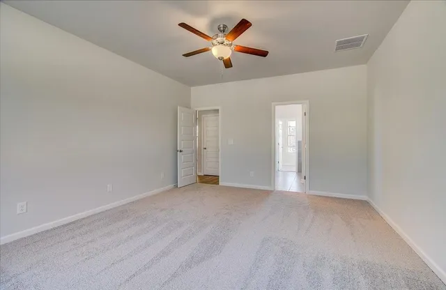 an empty room with closet and a ceiling fan