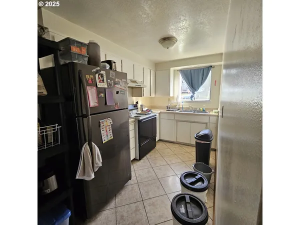 a kitchen with stainless steel appliances granite countertop a sink and a refrigerator