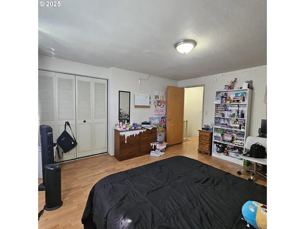 a living room with a bed furniture and a wooden floor