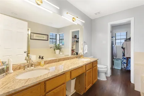 a bathroom with a granite countertop double vanity sink and a mirror