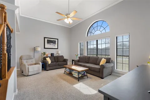 a living room with furniture a chandelier and a large window