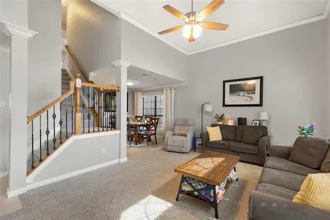 a living room with furniture and a ceiling fan