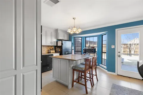a dining room with stainless steel appliances granite countertop furniture and a chandelier