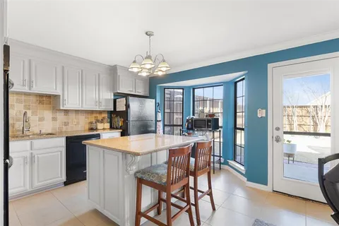 a kitchen with stainless steel appliances a table and chairs in it