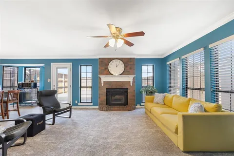 a living room with furniture a fireplace and a large window