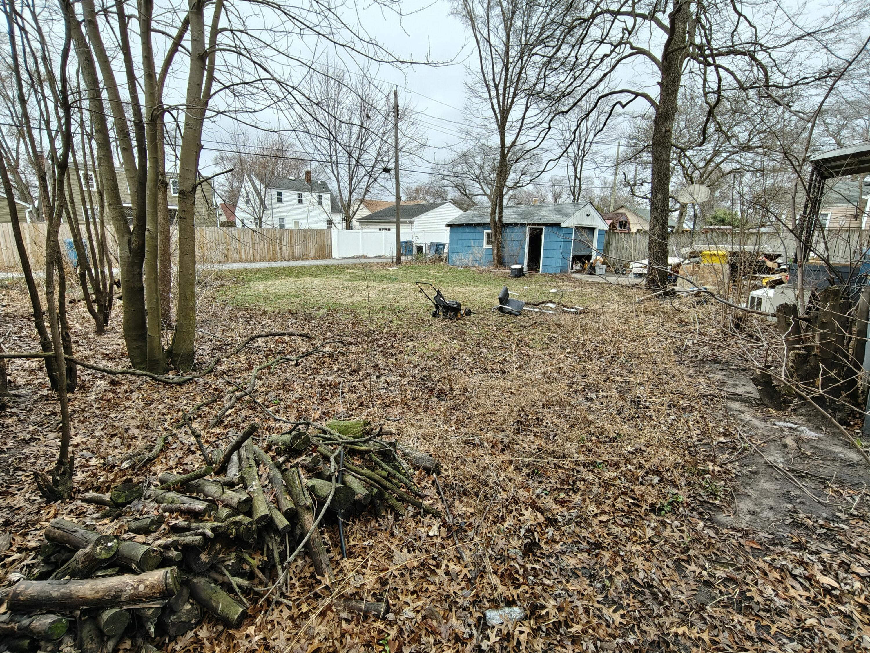 238 North Indiana Street Griffith, IN 46319 - Photo 22 of 23 a backyard of a house with large trees and outdoor seating
