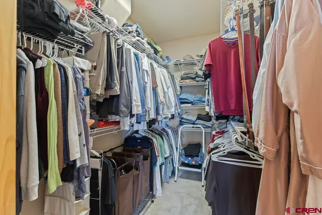 a view of walk in closet with clothes