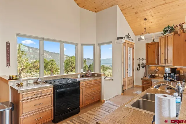 a large kitchen with a large window and stainless steel appliances