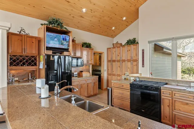a kitchen that has a sink cabinets and stainless steel appliances