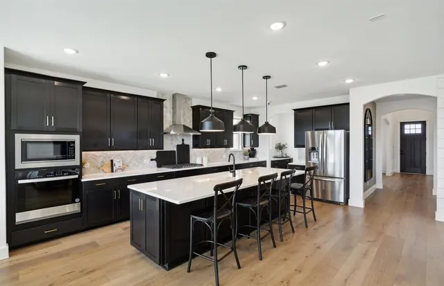 a large kitchen with lots of counter space a sink appliances and cabinets
