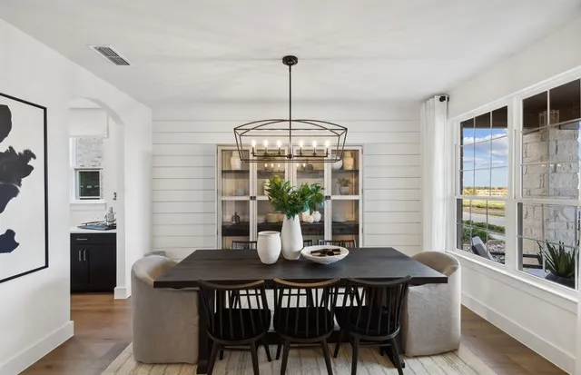 a dining room with furniture a chandelier and window