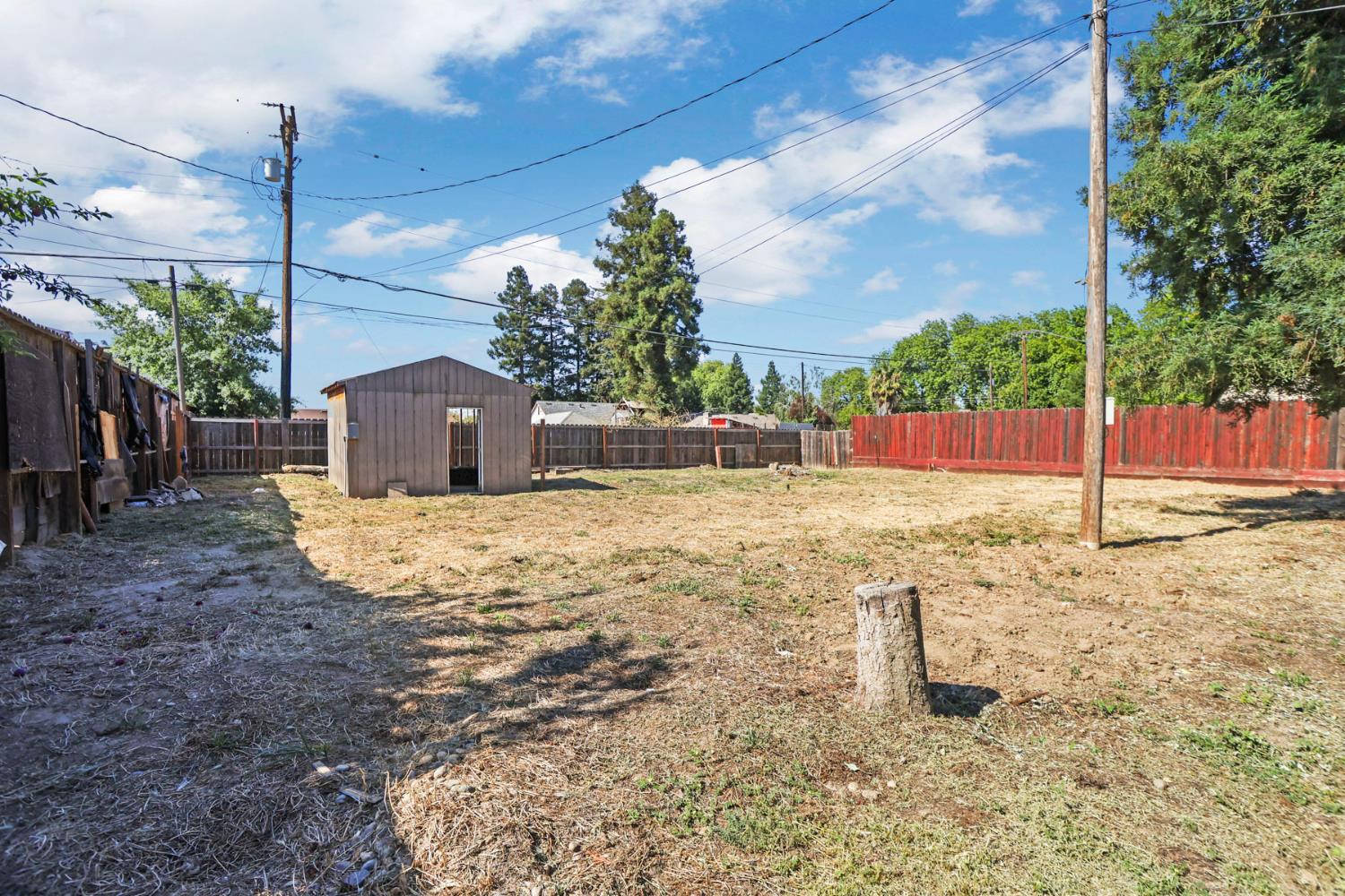 916 Elm Avenue Modesto, CA 95351 - Photo 31 of 52 Large rear yard with storage shed, fencing, and open space, highlighting the oversized lot and added outdoor utility