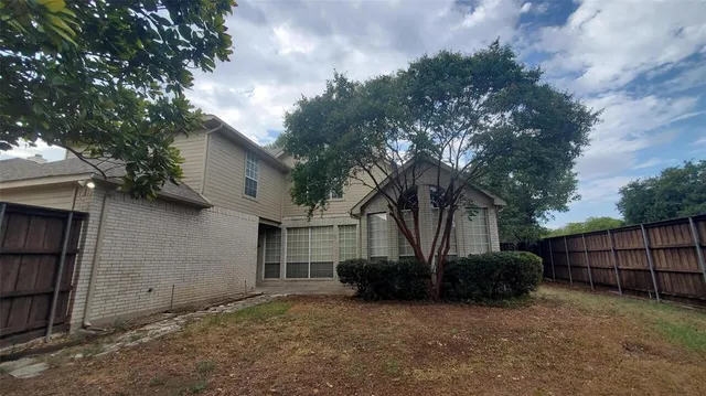 a view of a house with a tree in a backyard