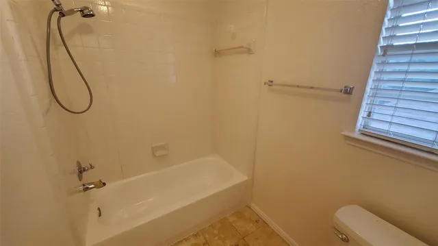 a bathroom with a shower and white walls
