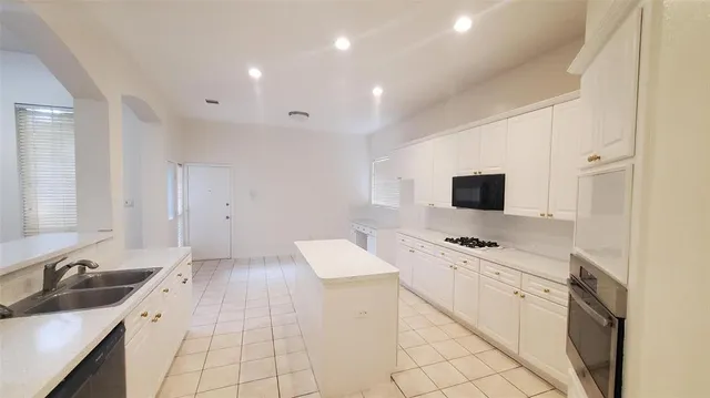 a kitchen with a sink appliances and cabinets