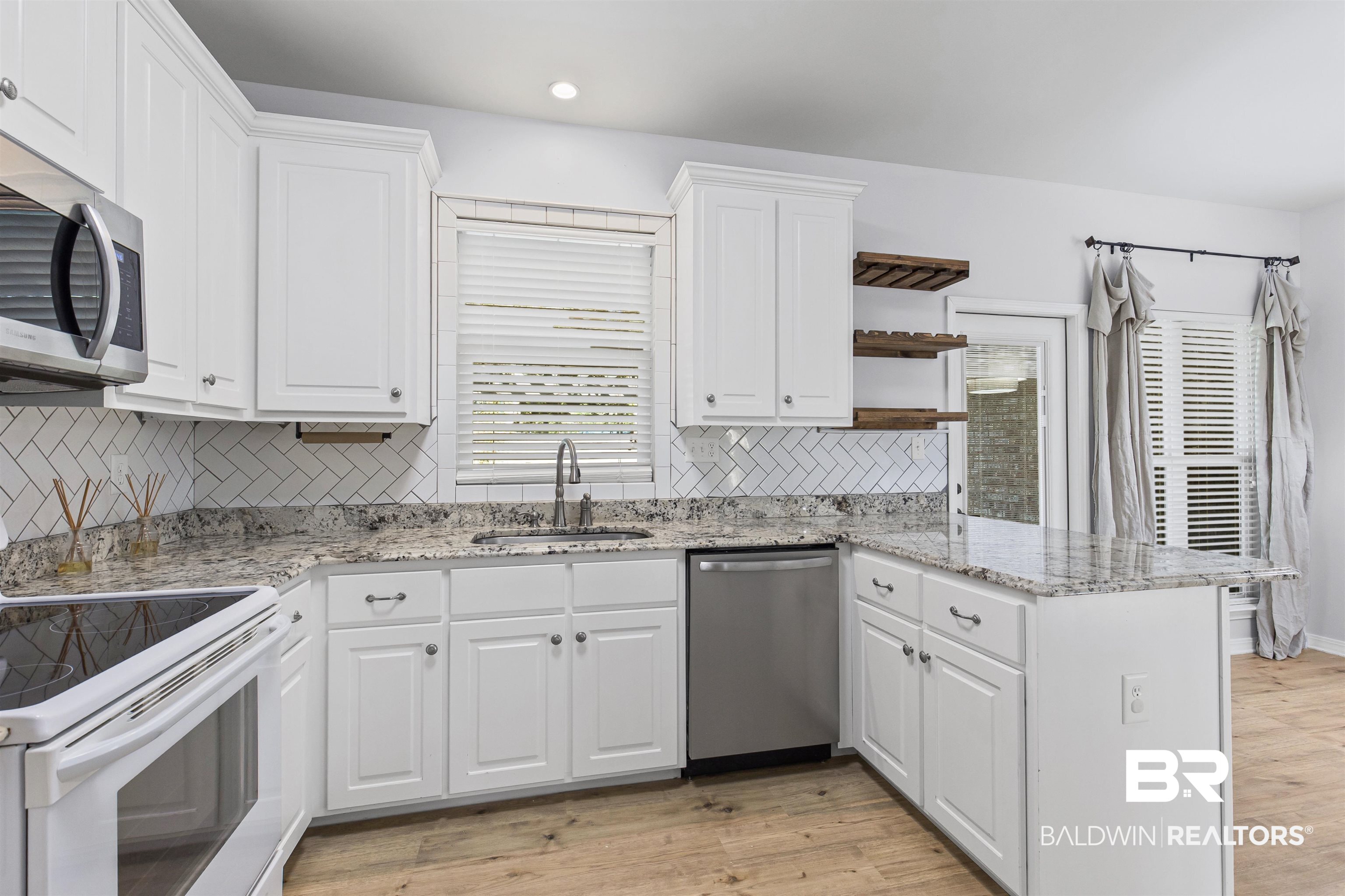 30851 Joseph Drive Spanish Fort, AL 36527 - Photo 7 of 22 Kitchen featuring stainless steel appliances, light stone counters, a peninsula, light wood-style floors, and recessed lighting