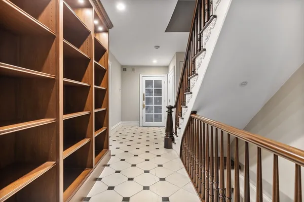 a walk in closet with wooden floor and stairs