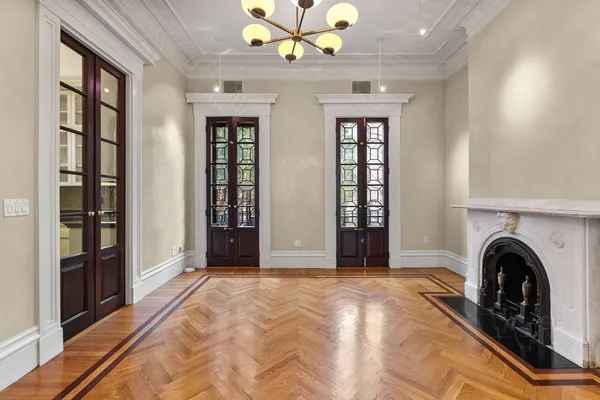 a view of an empty room with window and fireplace
