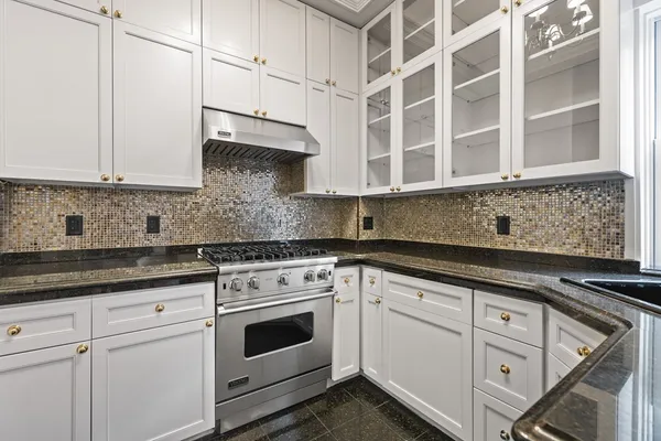 a kitchen with granite countertop a sink stainless steel appliances and cabinets
