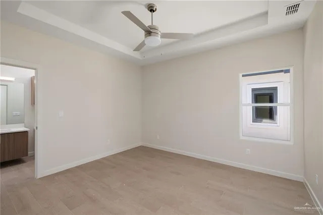 an empty room with a ceiling fan and a window