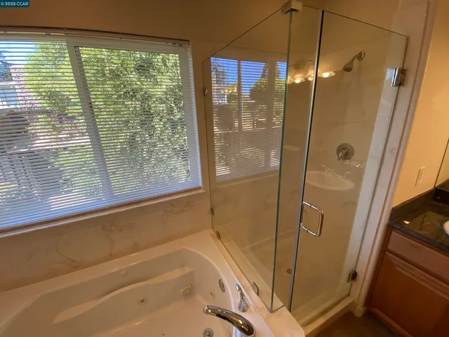 a bathroom with a granite countertop toilet and a shower
