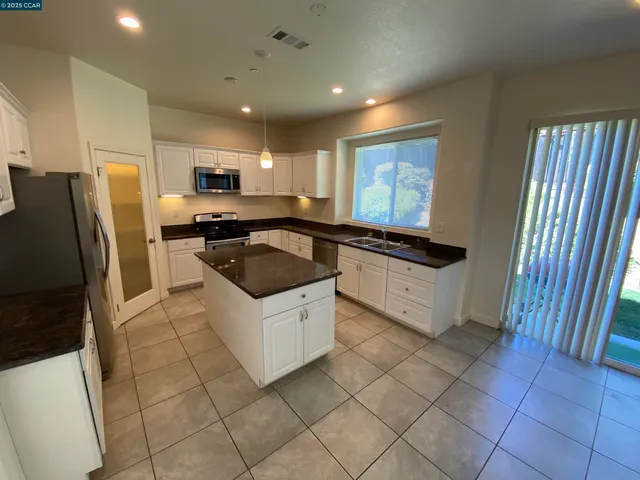 a kitchen with a sink a refrigerator and cabinets