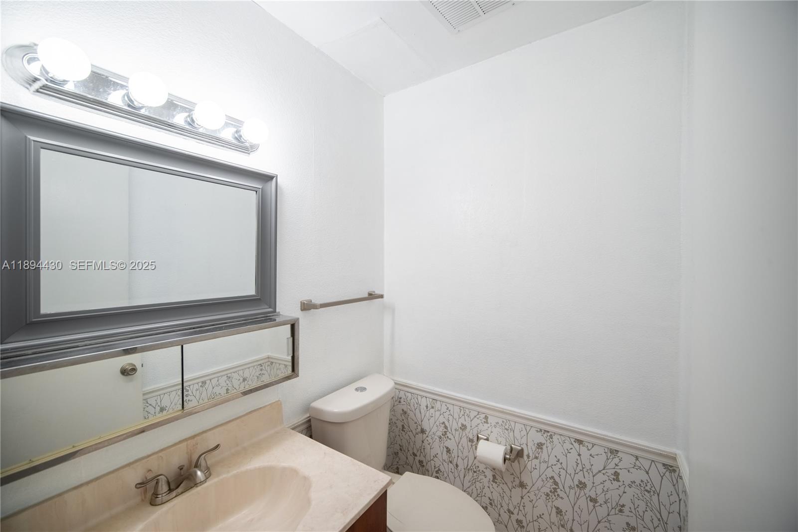 6845 Northwest 169th Street, Unit 41C Hialeah, FL 33015 - Photo 17 of 20 a bathroom with a sink a toilet and mirror