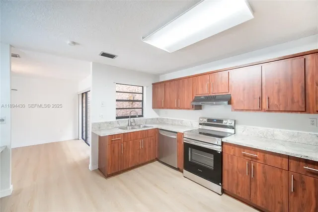 a kitchen with stainless steel appliances a sink stove and cabinets
