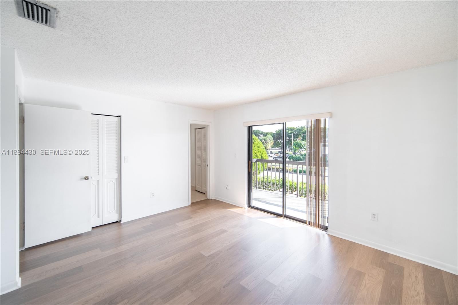 6845 Northwest 169th Street, Unit 41C Hialeah, FL 33015 - Photo 10 of 20 an empty room with wooden floor and windows